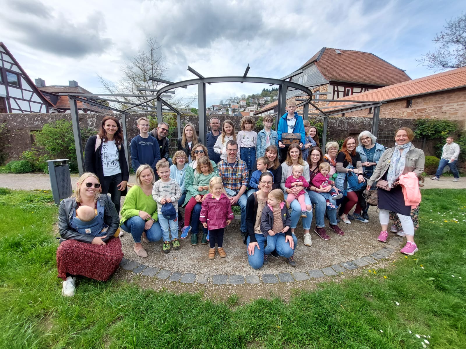 Gruppenbild Eltern mit Kindern vor einer Mauer, im Hintergrund Häuser von Steinau