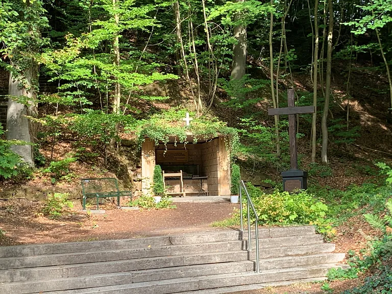 14. Station, kleine Grotte mit dem Grab Jesu, daneben ein großes Holzkreuz