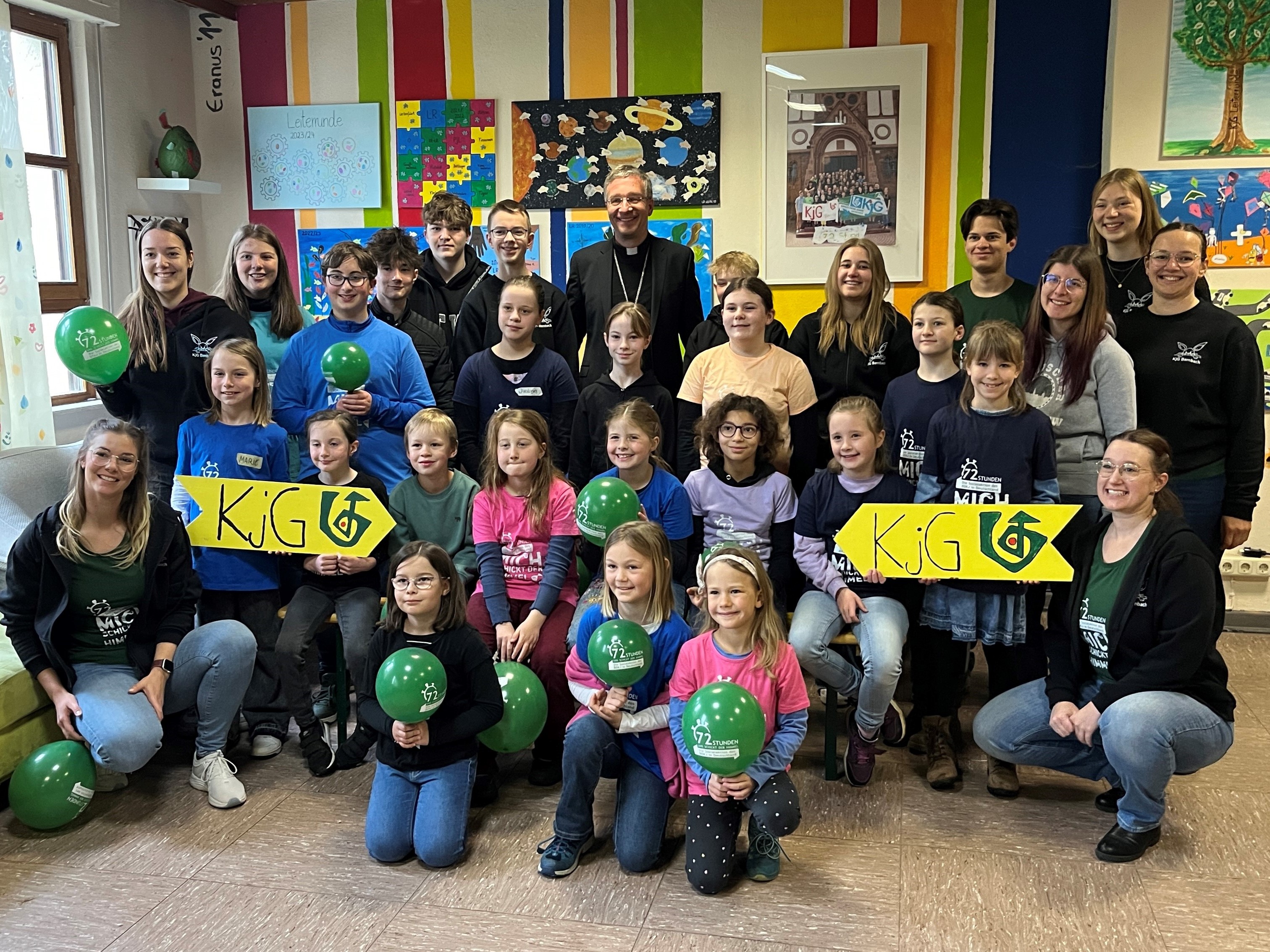 Gruppenbild mit vielen Kinder und zwei KjG Schildern, in der Mitte Bischof Dr. Gerber.