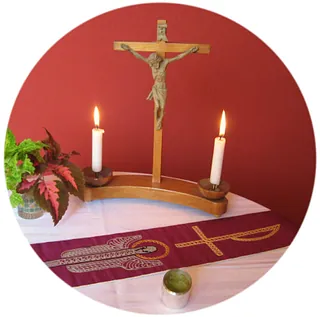 Kreuz mit zwei Kerzen, davor die violette Priesterstola und das Ölgefäß